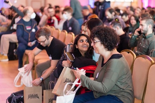 A few people in the front seats in the congress hall laden with swag
