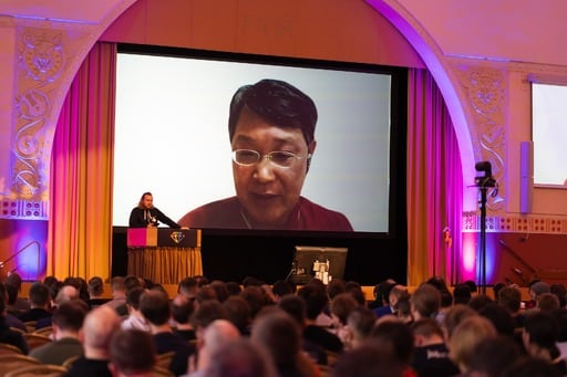 Matz answers questions remotely, audience in foreground