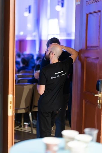 A man in an AppTweak shirt watches the talk