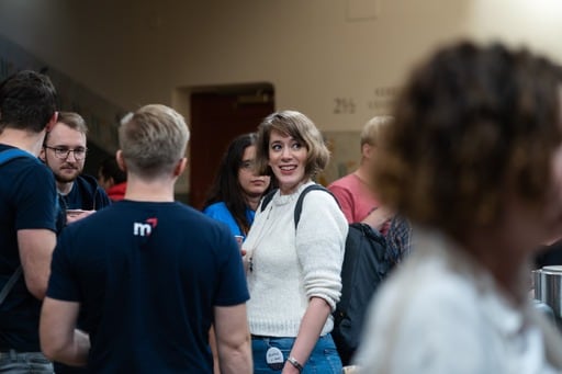 Photo of people in the foyer centered on a woman in a white sweater