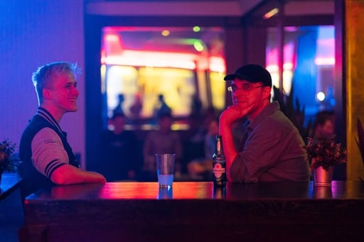 Two people facing each other across the tabke, photo from the side