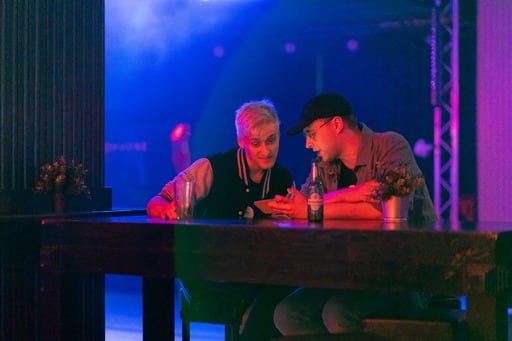 One person showing something to another on his phone