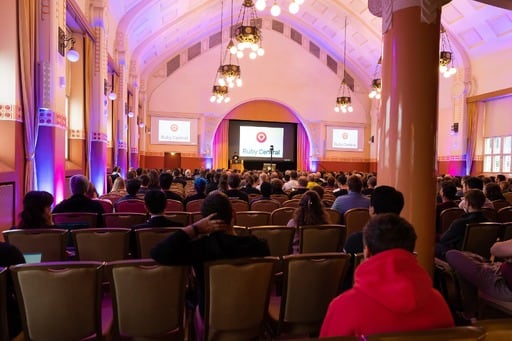 Adarsh Pandit presenting his talk, Ruby Central logo on screen