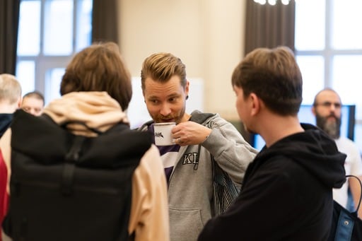 Three men having a talk and coffee in the foyer